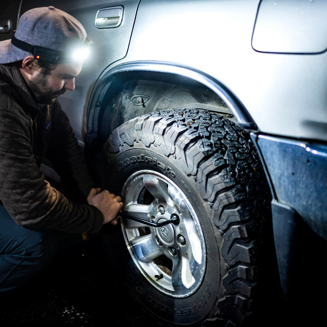 Person wearing wide angle headlamp/ head torch while doing car repairs