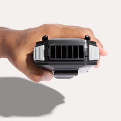 Hand holding ArcticFan portable waist fan, showing top of device