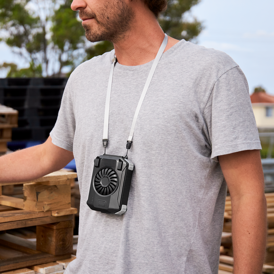Trades worker keeping cool outdoors with portable fan worn around neck