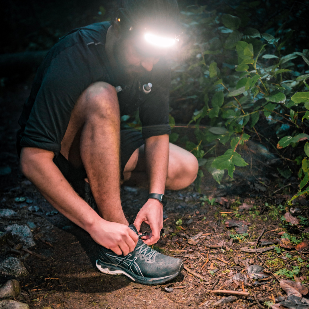 Trail runner wearing wide angle headlamp/ head torch while running