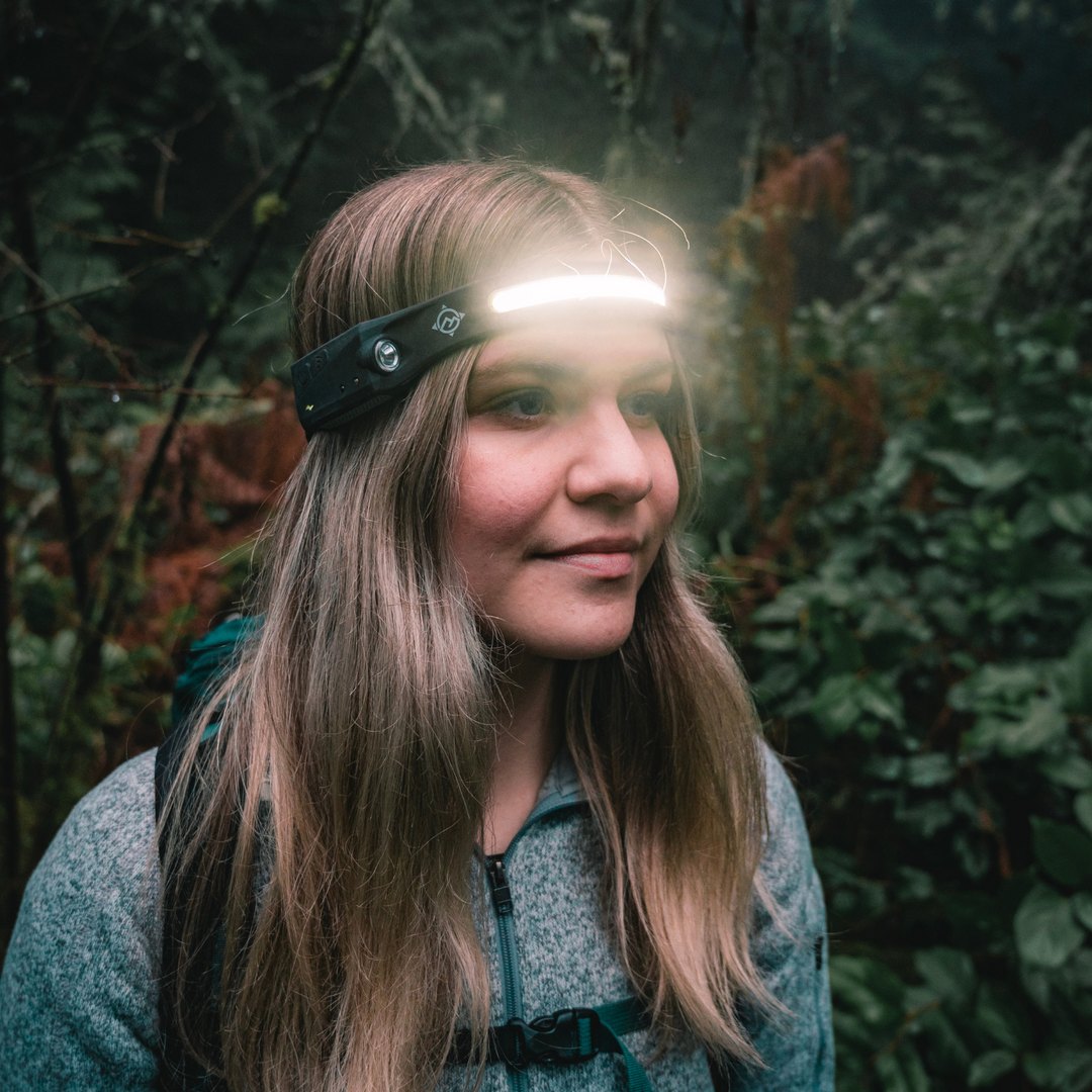 Woman wearing wide angle headlamp/ head torch while hiking
